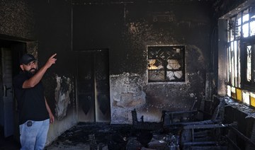 A Palestinian gestures inside his home, which was set on fire by Israeli settlers the day before, in Turmus Aya near Ramallah.